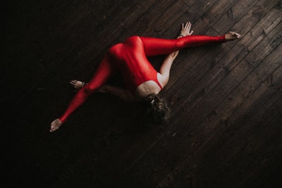 A woman cheating on forward lying on the parquet floor
